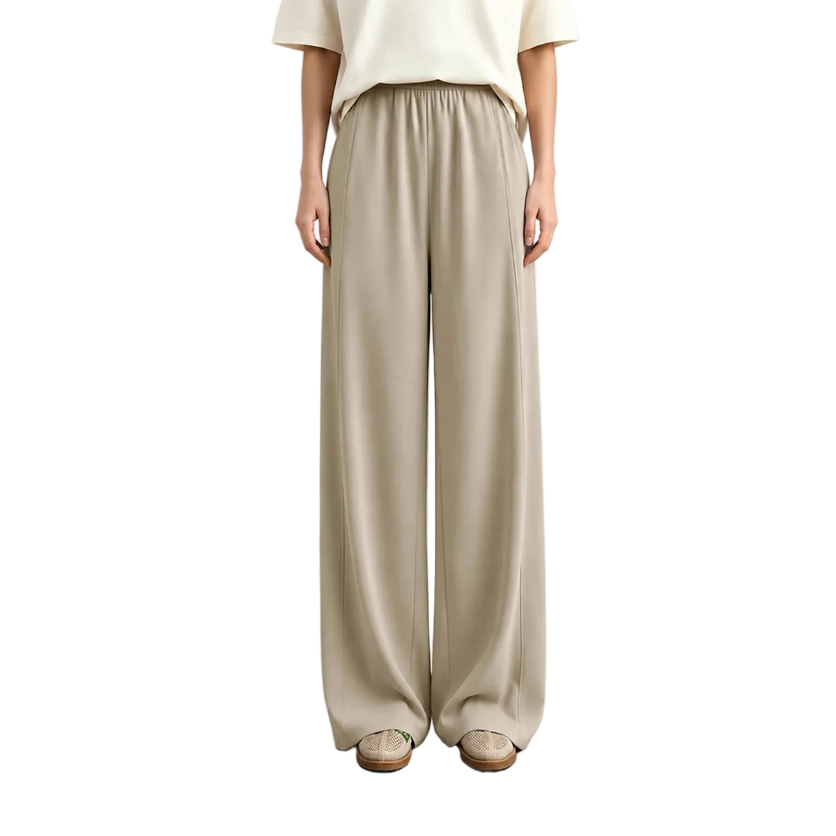 A model from the waist down wearing AMII wide-leg trousers in a light beige color, paired with a cream top and beige shoes, standing against a neutral studio background.