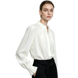A woman modeling a white long-sleeve blouse with a high gathered collar and button front, paired with black high-waisted trousers. The AMII brand logo is visible in the top left corner against a clean white background.