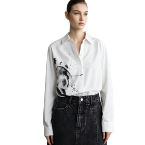 A model wearing a white long-sleeve button-up shirt with a black and gray abstract brushstroke print on the front, paired with a dark denim skirt. The brand name 'AMII' is visible in the top left corner.