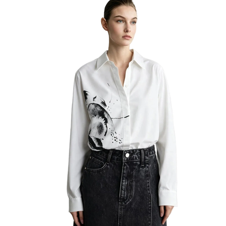 A model wearing a white long-sleeve button-up shirt with a black and gray abstract brushstroke print on the front, paired with a dark denim skirt. The brand name 'AMII' is visible in the top left corner.