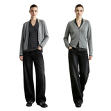 Two models standing side by side in a studio setting, wearing matching gray cardigans over dark V-neck tops and black wide-leg trousers.