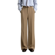 A model from the waist down wearing AMII wide-leg trousers in a light tan color, paired with a light blue button-down shirt and dark brown leather shoes, set against a plain light gray studio background.