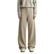 A model wearing AMII wide-leg knit trousers in a light beige color, paired with a textured beige sweater and cream shoes, standing against a neutral gray studio background.