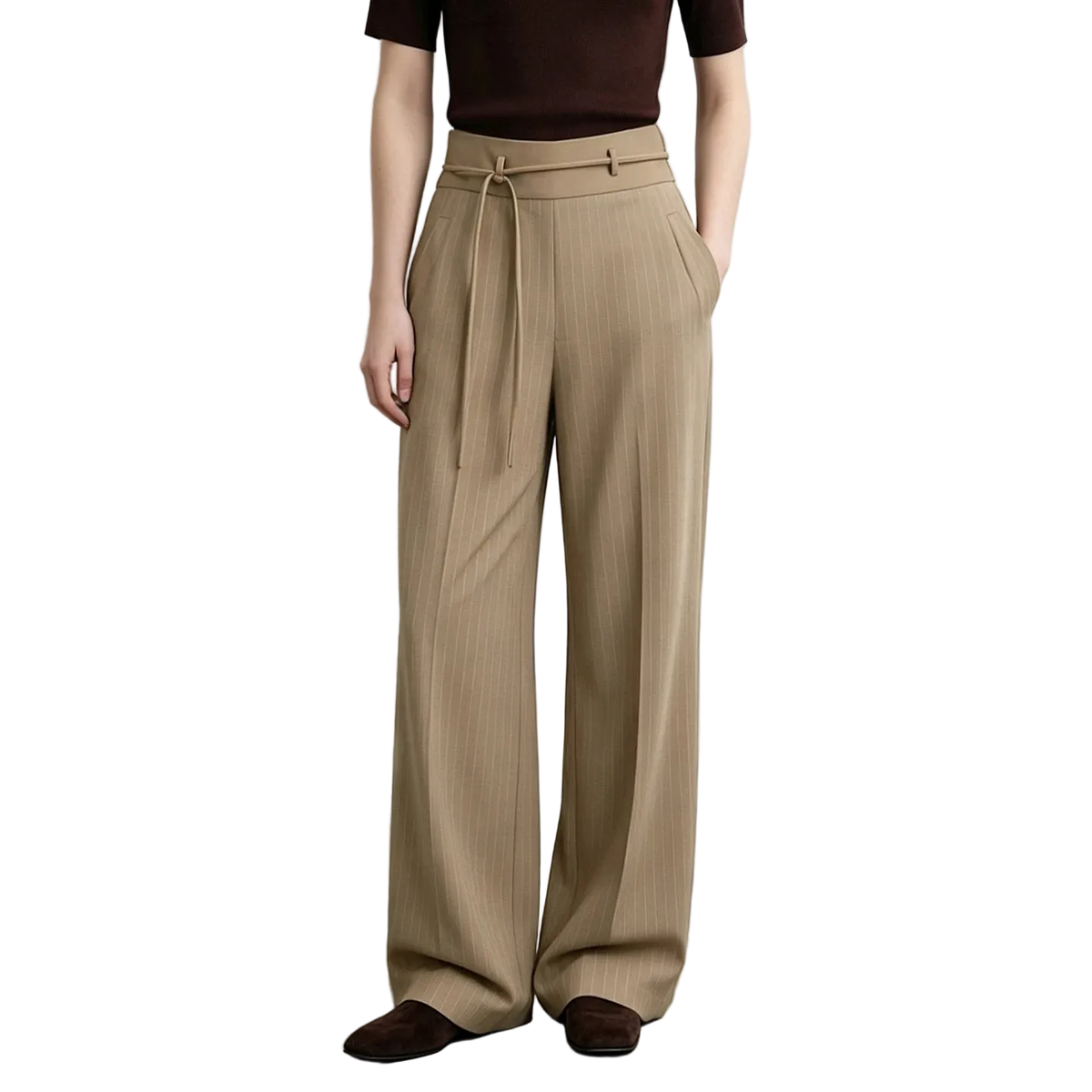 A model wearing AMII beige wide-leg pleated trousers with a drawstring waist, paired with a dark brown top and brown suede loafers, set against a minimalist studio background.