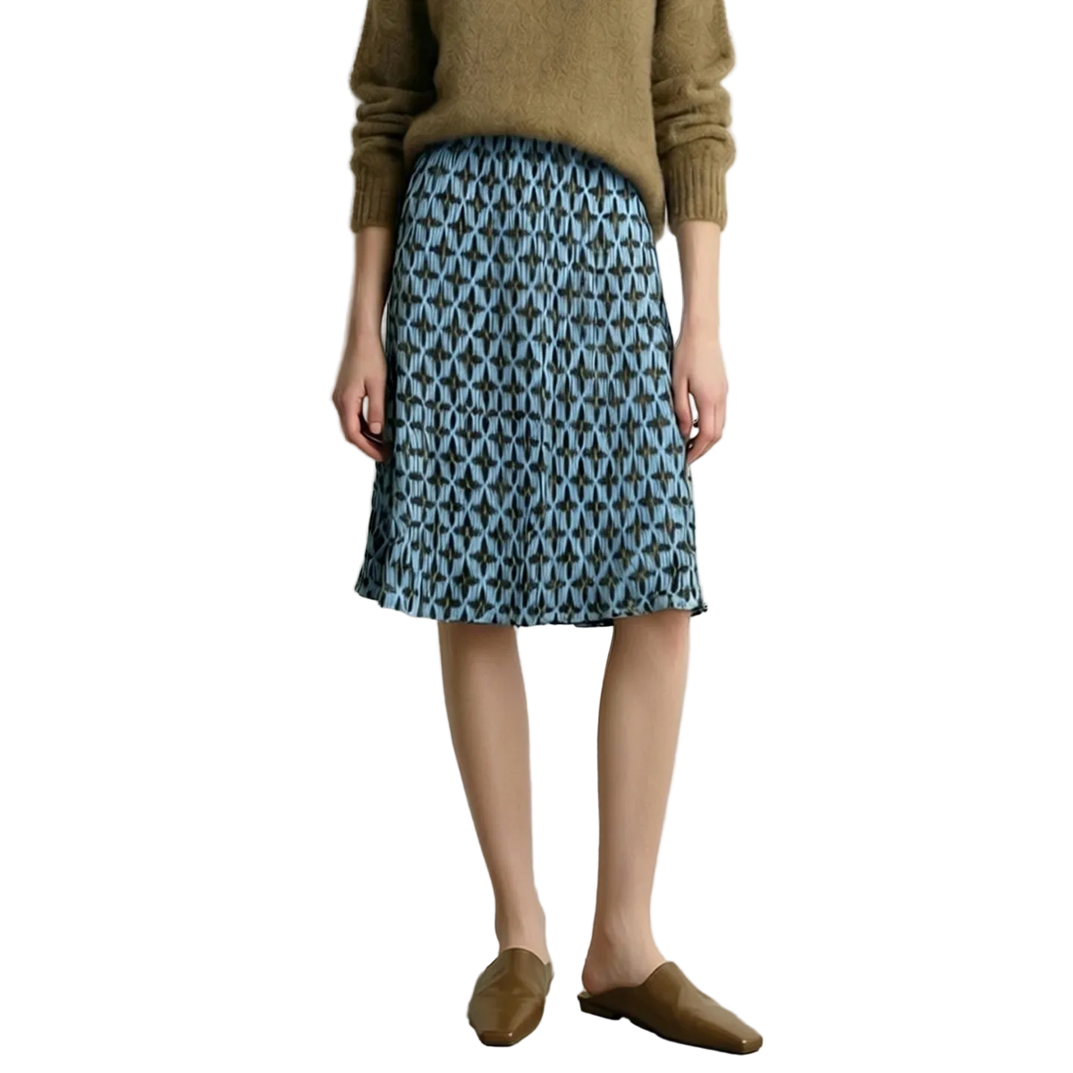 A model wearing a blue and gray geometric patterned midi skirt with a brown knit sweater and brown mule loafers, standing against a light gray wall. The brand name AMII is visible in the top left corner.
