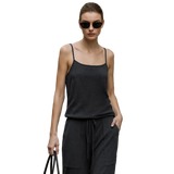 A woman wearing a dark charcoal gray sleeveless camisole top and matching drawstring pants stands outdoors against a beige stone building. The AMII brand name appears at the top left, and a product info panel on the left mentions mulberry silk and sheep wool yarn.