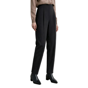 A model wearing black high-waisted, straight-leg trousers with pleats, paired with a beige sweater and black pointed-toe ankle boots. The AMII brand logo is visible in the top-left corner against a neutral light gray studio background.