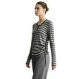 A woman modeling a long-sleeve gray and black striped knit top with a side-tie detail, paired with gray drawstring pants, against a light gray studio background. The brand name AMII is printed in the top left corner.