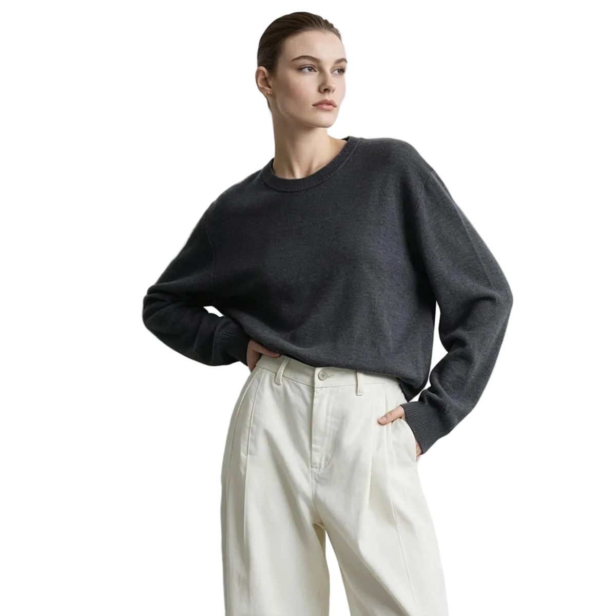 A woman wearing a dark charcoal gray long-sleeve knit sweater and cream-colored high-waisted trousers, standing against a light gray studio background with the AMII logo in the top left corner.