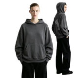 A model wears a dark gray AMII pullover hoodie with a kangaroo pocket, shown from the front and back against a minimalist light gray studio background.