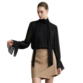 A model wearing an AMII black sheer long-sleeve blouse with a high mock neck and dramatic flared bell sleeves, paired with a beige mini skirt, against a light gray studio background.